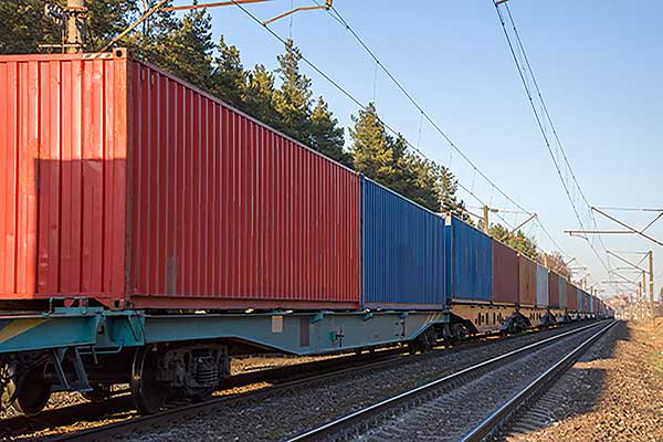 Containerzug fährt durch Landschaft