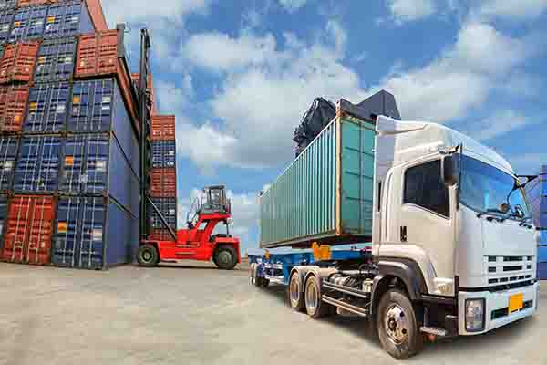 Container truck in front of stacked freight containers