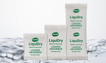 LiquiDry Flüssigkeitsabsorber Sachets vor einer Flüssigkeit